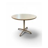 Steelcase bistro table featuring a light-colored laminate top and a beige four-star pedestal base