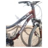 Maroon Specialized Hotrock 24 mountain bike with 24-inch wheels.