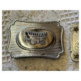 Western-themed belt buckles including intricate wagon design, longhorn motif, and a rhinestone-studded buckle