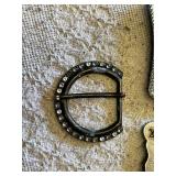 Western-themed belt buckles including intricate wagon design, longhorn motif, and a rhinestone-studded buckle