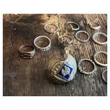 Lot of various silver and gold rings, including ornate designs and a large decorative shield-style ring and wolf insignia ring