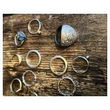 Lot of various silver and gold rings, including ornate designs and a large decorative shield-style ring and wolf insignia ring