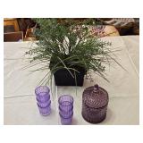 Artificial lavender plant in a black pot, set of purple glasses, and a purple glass container with lid