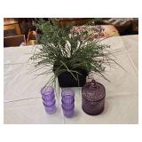 Artificial lavender plant in a black pot, set of purple glasses, and a purple glass container with lid