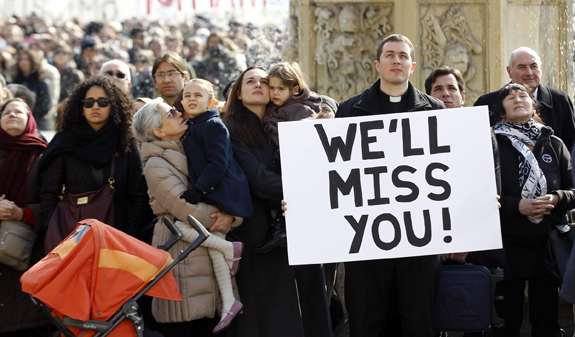 People in St. Peter's Square watch as Pope Benedict XVI leads Angelus