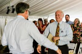 Bill Durham approaching Paul Fisher (back of Paul) with onlookers from audience in tent
