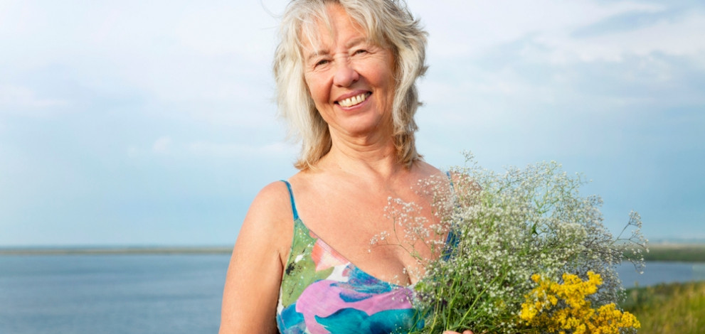 Smiling,Elderly,Woman,In,A,Summer,Sundress,Holding,Flowers,In