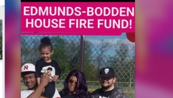 A family of four poses outdoors below a banner reading Edmunds-Bodden House Fire Fund!