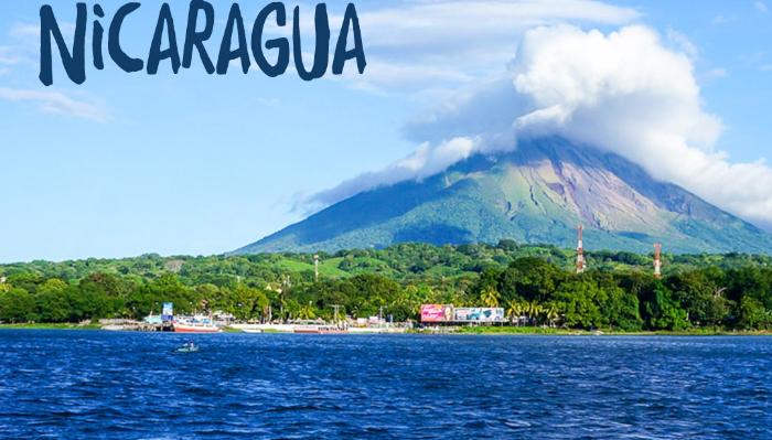 A cloud-capped volcano rises above a blue lake and green shoreline with text reading "Nicaragua" overhead.