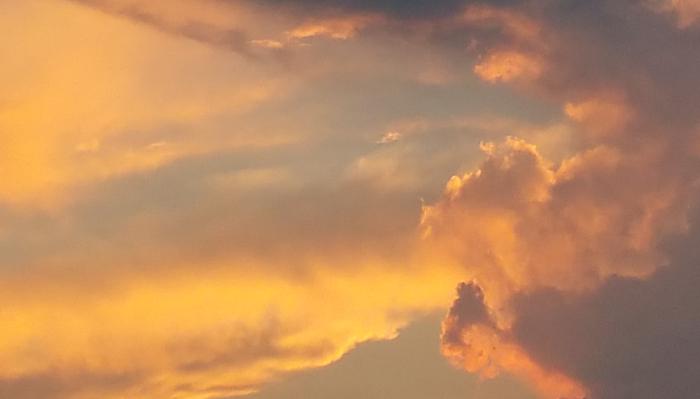 Glowing golden and orange sunset clouds illuminated across a twilight sky.