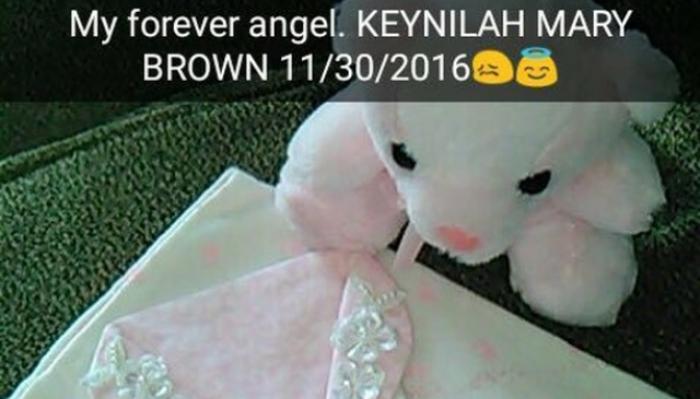 Pink plush bear beside a baby bonnet with text overlay: "My forever angel. KEYNILAH MARY BROWN 11/30/2016".