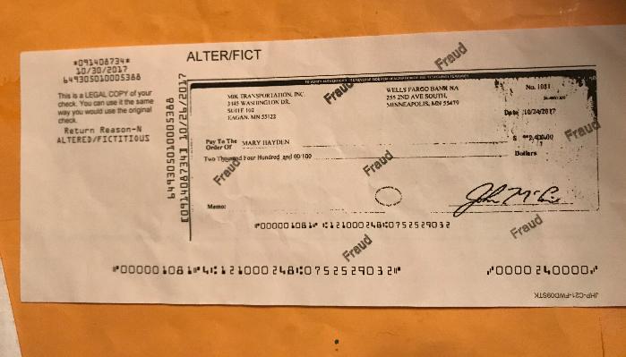 A copy of a $2,400 bank check stamped multiple times with the word Fraud and marked altered/fictitious.