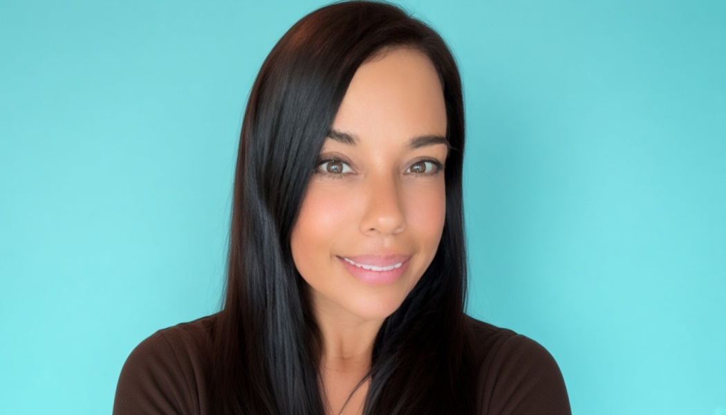 A smiling woman with long dark hair against a bright turquoise background.