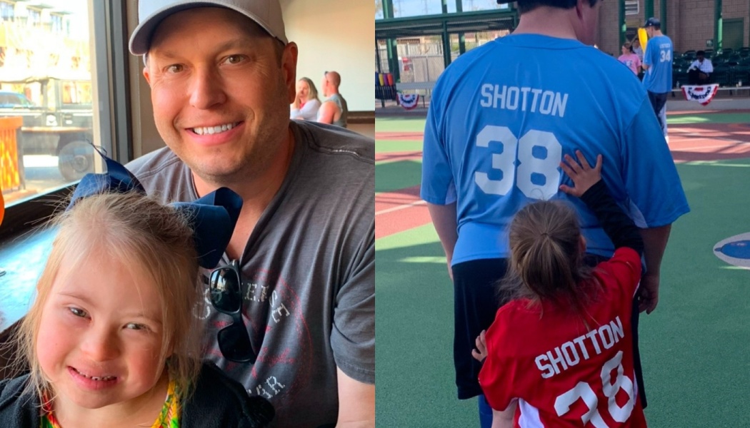 A smiling father and young daughter together, and seen from behind outdoors wearing matching sports jerseys.