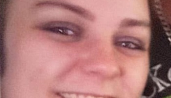 Close-up portrait of a smiling young woman looking at the camera.