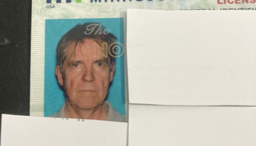 A Minnesota ID card featuring a portrait of a man, with personal details covered by white paper.