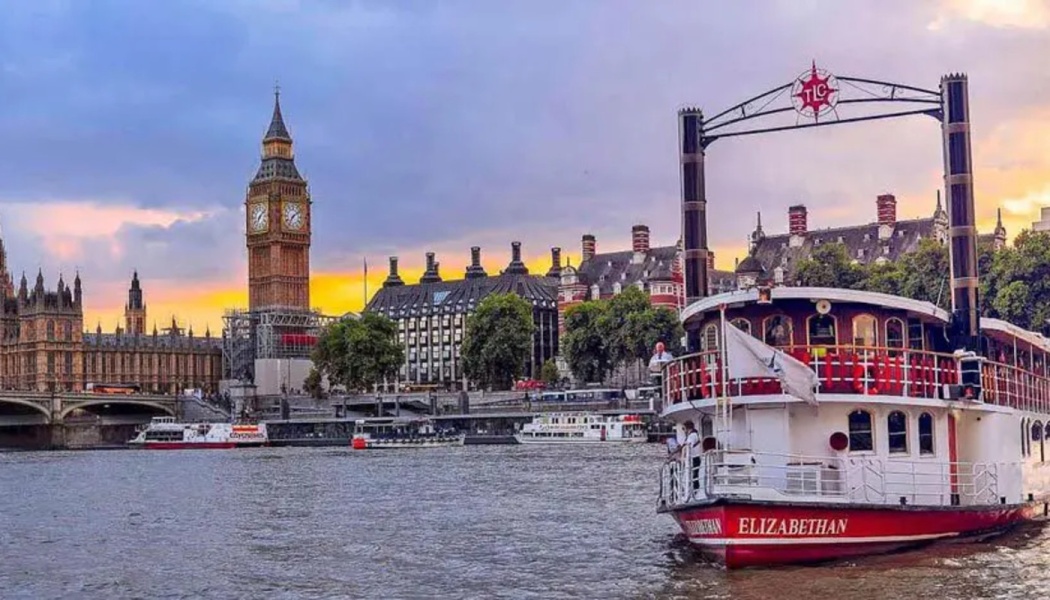 The riverboat Elizabethan sails on the River Thames in London, with Big Ben and Parliament at sunset.