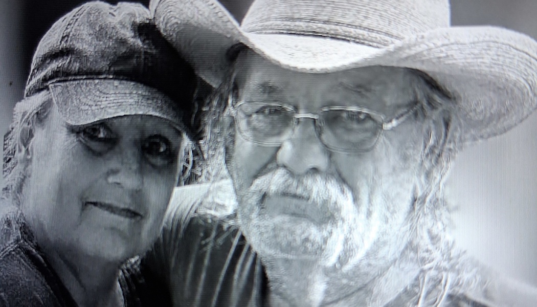 Black and white portrait of a woman in a baseball cap next to a man wearing glasses and a cowboy hat.