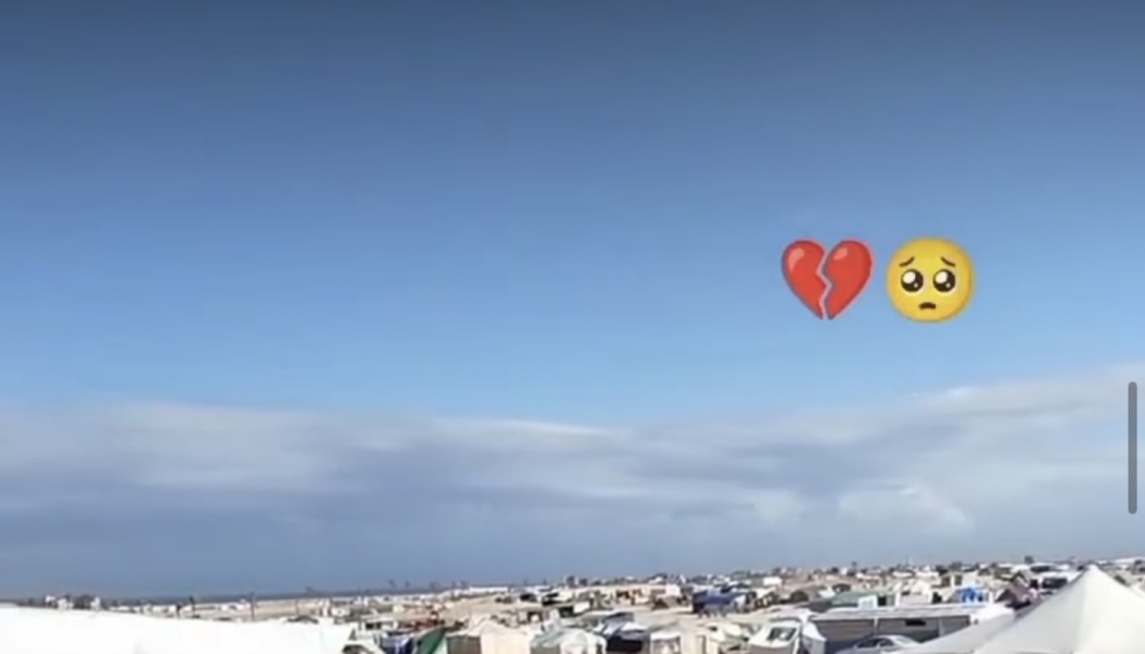 Sprawling tent camp under a blue sky, overlaid with broken heart and sad pleading face emojis.