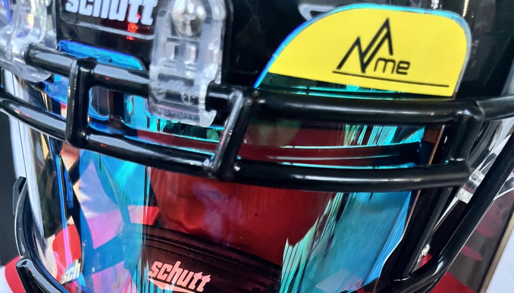 Black football helmet featuring a reflective blue visor and a yellow logo tab.