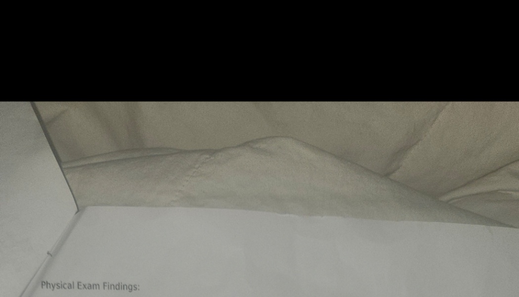 Printed medical document with the heading "Physical Exam Findings:" resting on soft bedding.