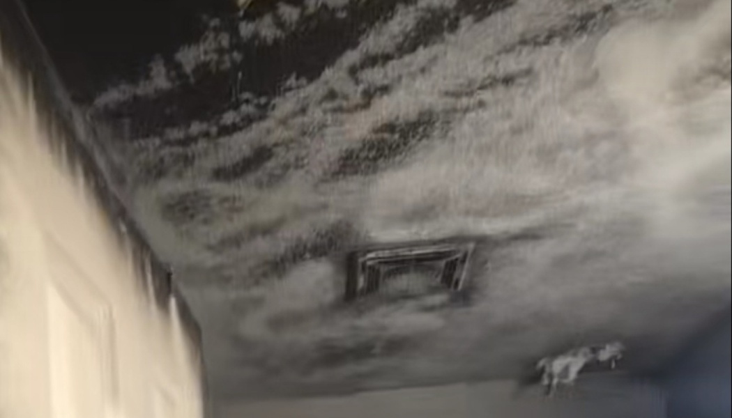 Heavy black soot and smoke damage covering a ceiling and air vent after a house fire.