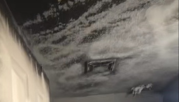 Heavy black soot and smoke damage covering a ceiling and air vent after a house fire.
