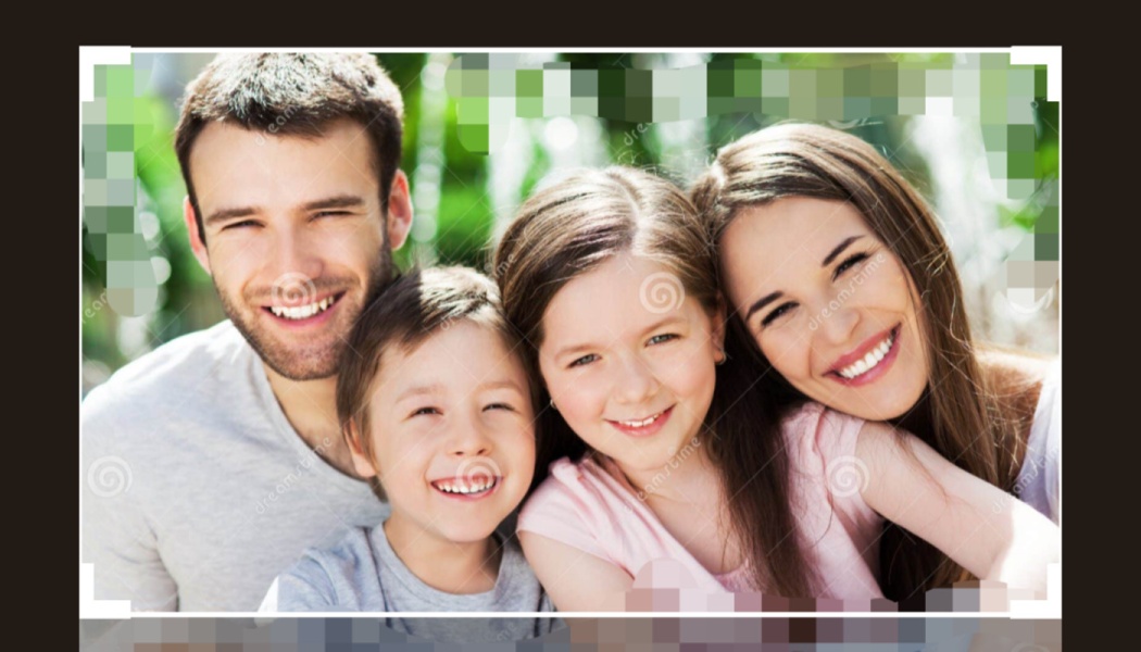 Happy family of four with a father, mother, son, and daughter smiling together outdoors.