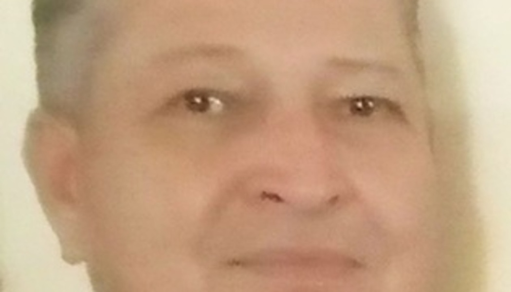 Close-up portrait of a middle-aged person looking directly forward with a soft smile.