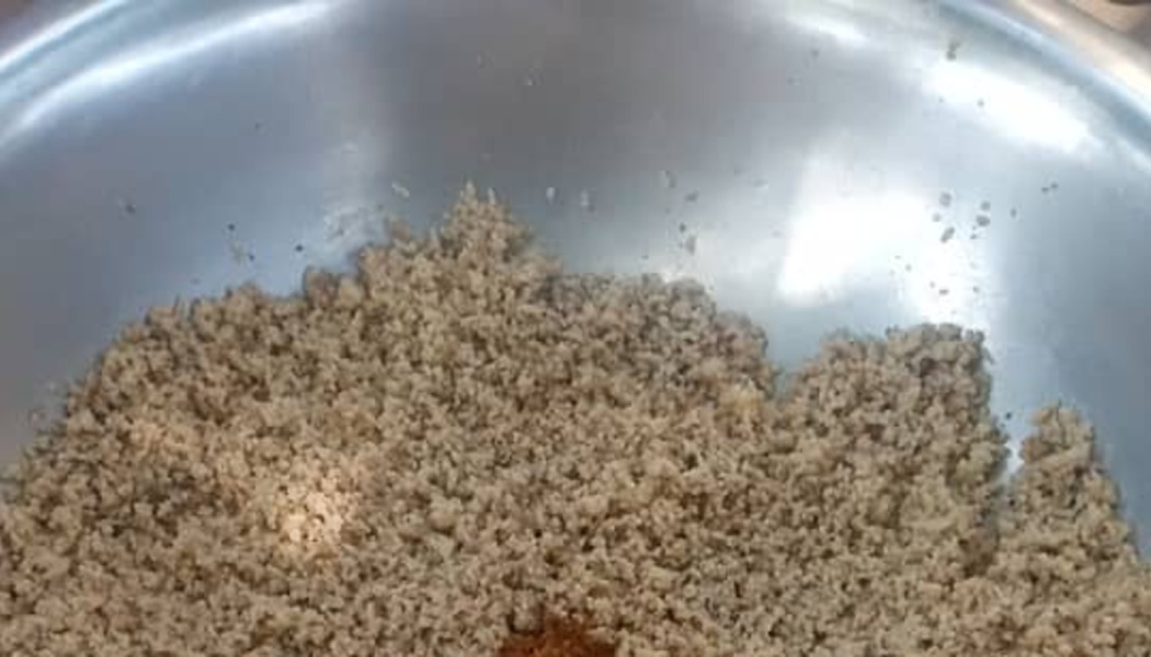 Minced ground meat mixture with spices inside a large stainless steel bowl.