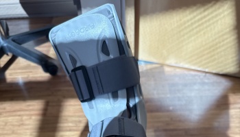 A grey Aircast medical walking boot strapped around a person's foot and lower leg.