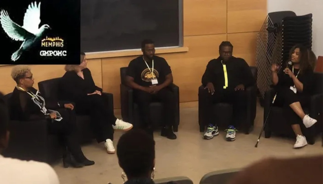 Five panelists sit in armchairs during a panel discussion, with a woman on the right speaking into a microphone.