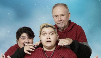Three people in matching red hoodies pose with playful expressions against a light blue backdrop.