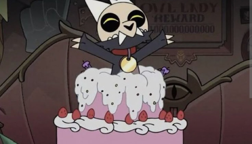 King from The Owl House pops joyfully out of a large pink cake decorated with white frosting and strawberries.