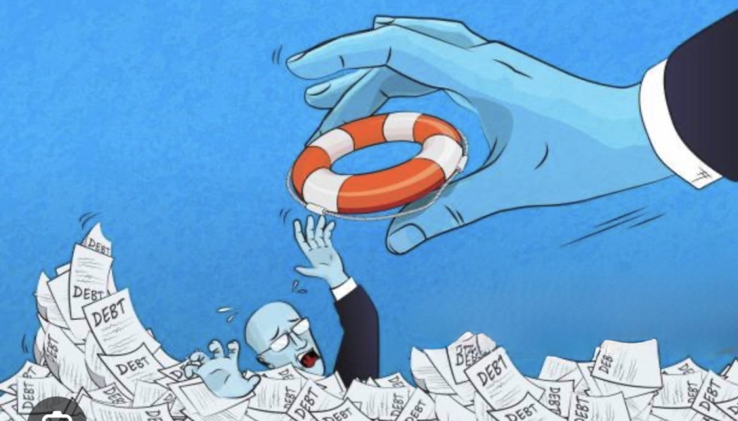 A giant hand drops a life preserver to a man drowning in a sea of papers labeled 'DEBT'.