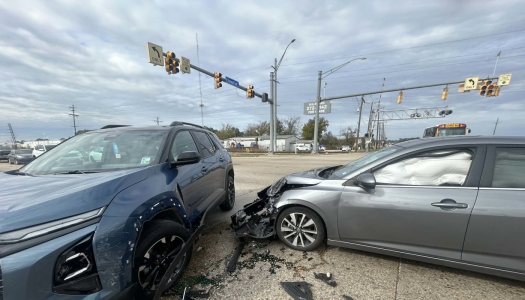 A blue SUV and a gray sedan collided at an intersection, with heavy front-end damage and deployed airbags.