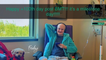 Smiling bald patient in a teal robe in a hospital chair next to a dog. Overlay text says: Happy +100th day post BMT!