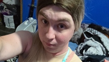 Close-up selfie of a person with long blonde hair looking directly into the camera.