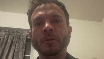 Close-up portrait of an emotional man with facial hair looking directly into the camera.
