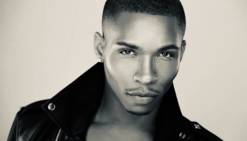 Black and white headshot of a young Black man wearing a black leather jacket with a popped collar.