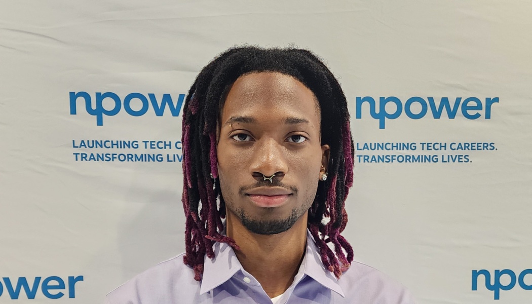 Headshot of a young Black man with purple-tipped dreadlocks and a nose piercing in front of an NPower backdrop.