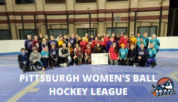 Pittsburgh Women's Ball Hockey League players pose together on an outdoor dek hockey court.