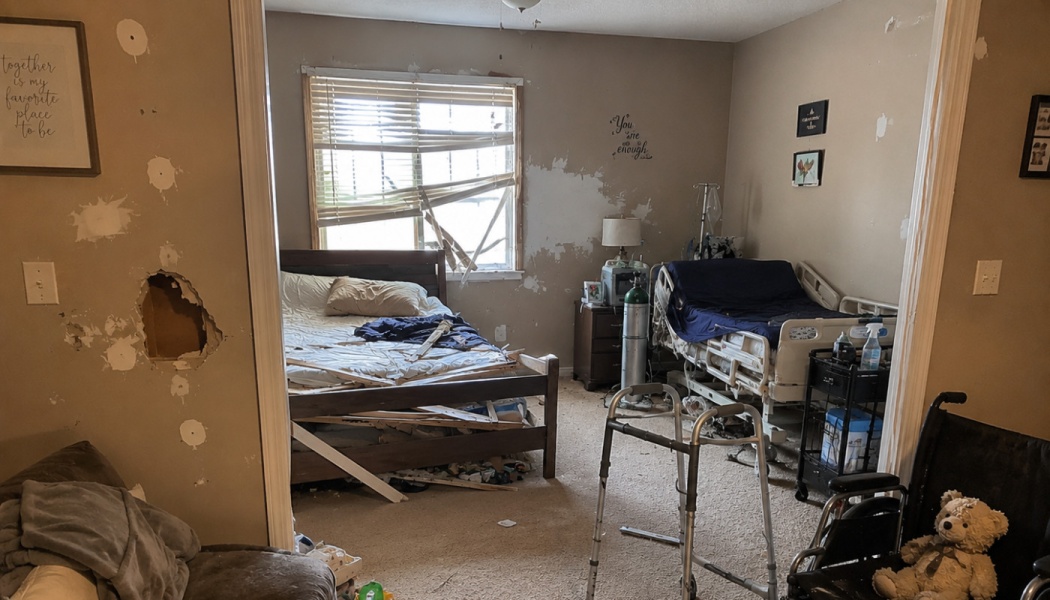 Damaged room with a broken bed, hole in wall, hospital bed, walker, and a wheelchair with a teddy bear.
