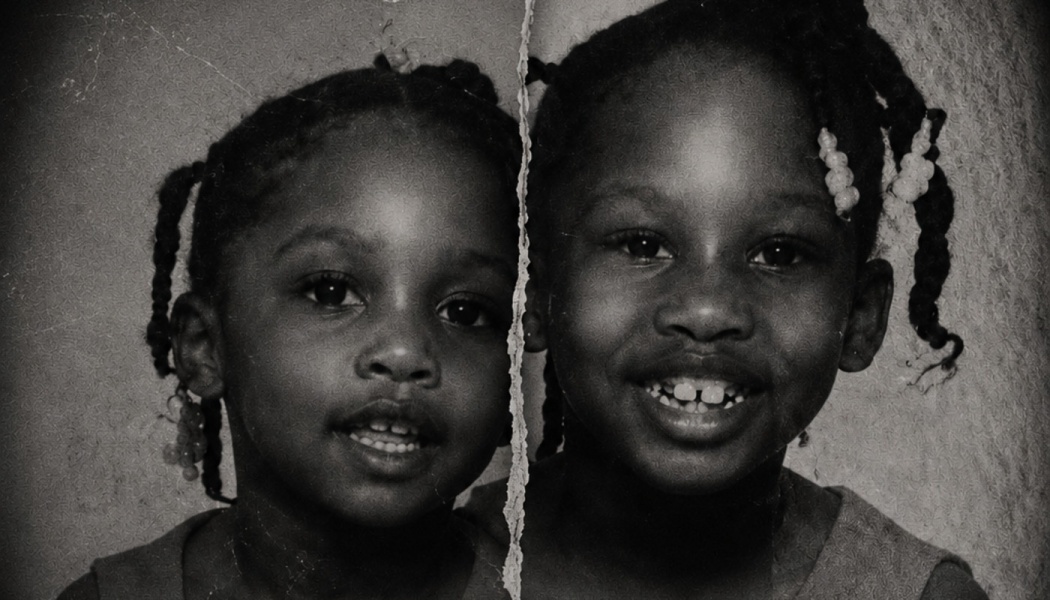 Vintage black-and-white portrait of two smiling young Black girls, torn down the middle.