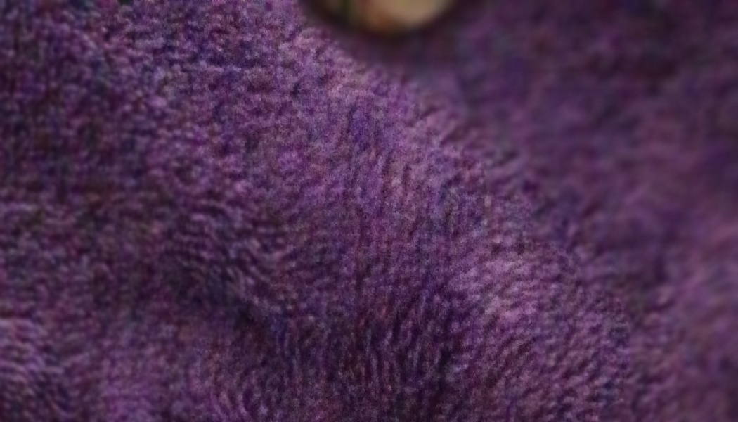 Close-up of plush, textured purple fabric with soft folds.