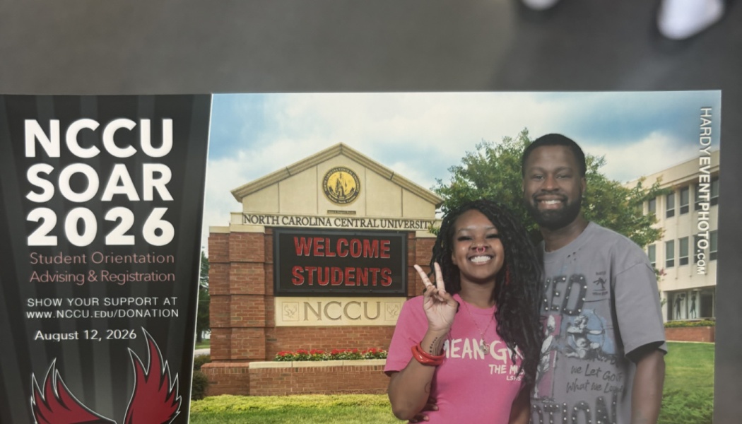 A smiling couple in front of the North Carolina Central University sign for NCCU SOAR student orientation.