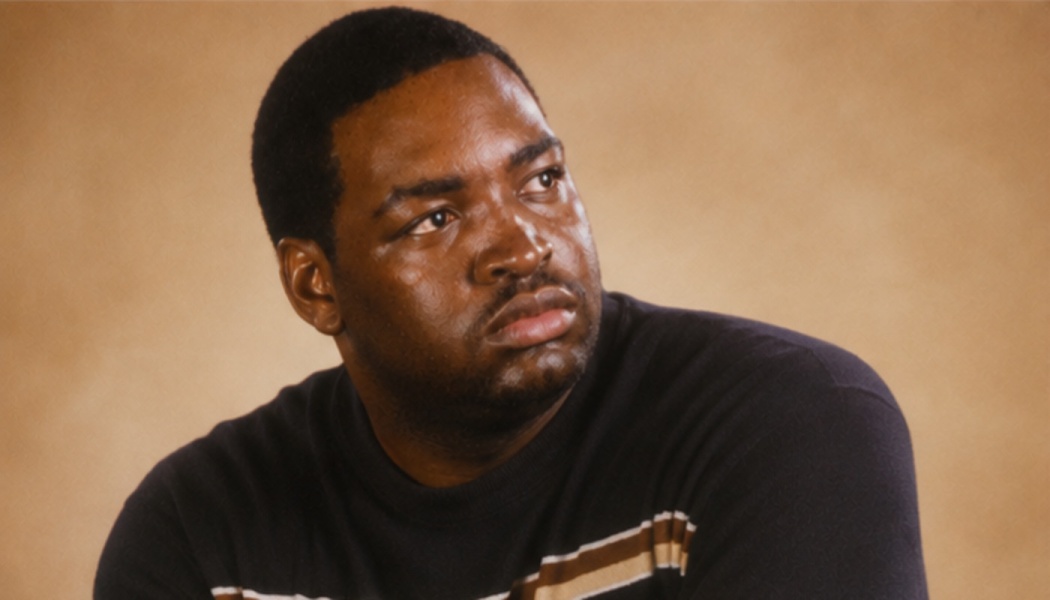 Rodney King looking thoughtfully off-camera, wearing a dark sweater with beige stripes.