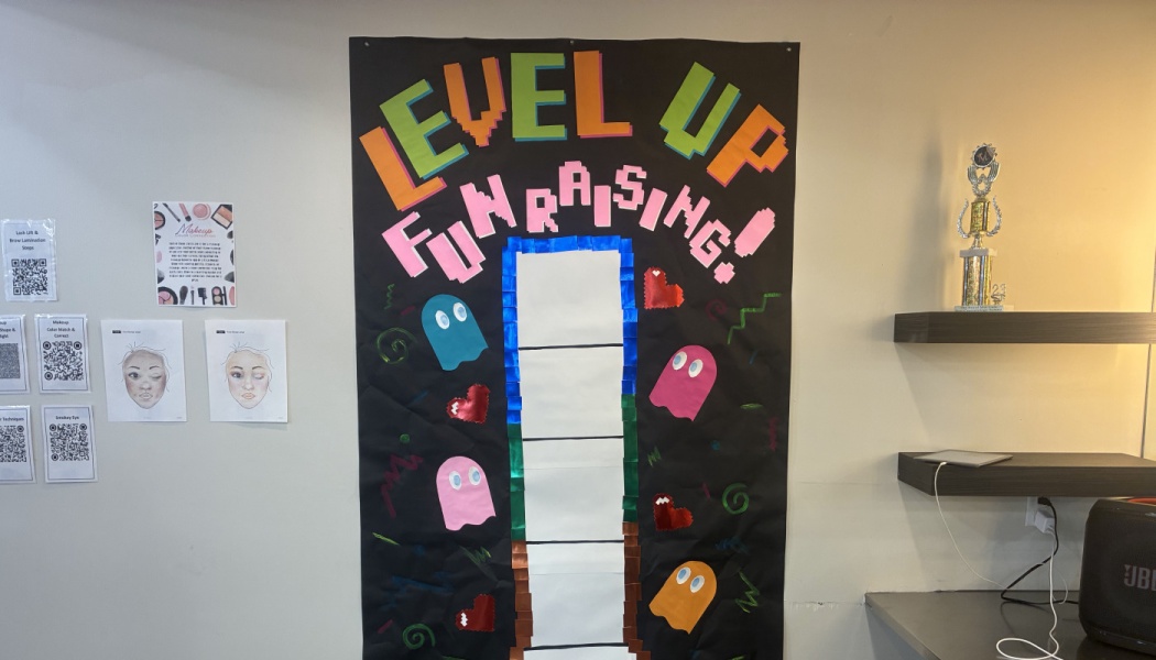 Arcade-themed poster reading "LEVEL UP FUNDRAISING!" featuring colourful video game ghosts and a progress tracker.