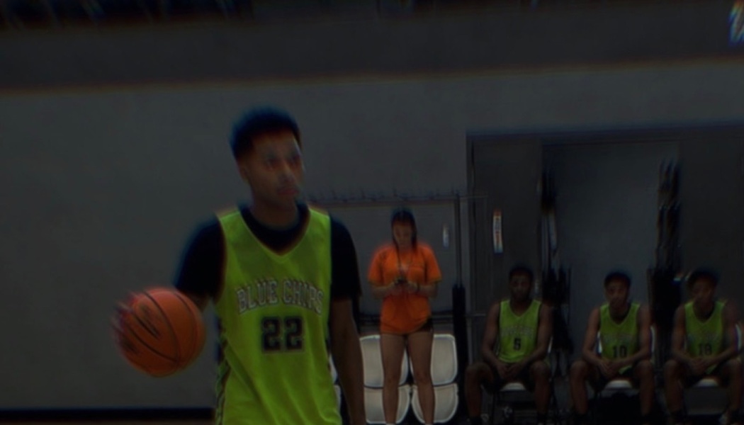 Young basketball player wearing a neon green Blue Chips jersey number 22 dribbling a basketball.