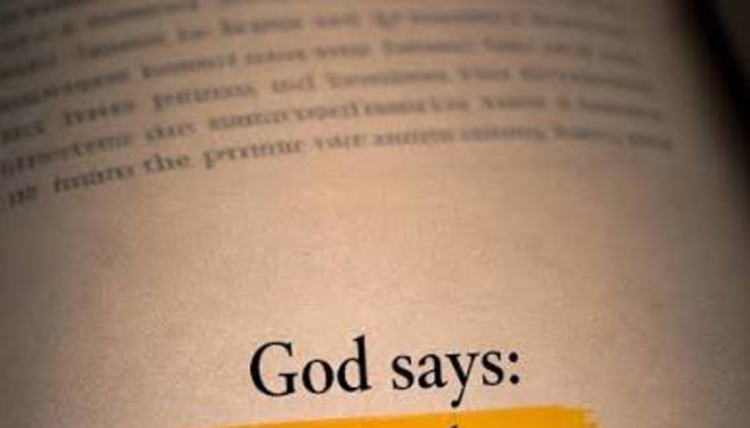 Close-up of a book page with the text "God says:" printed clearly above a yellow highlight.